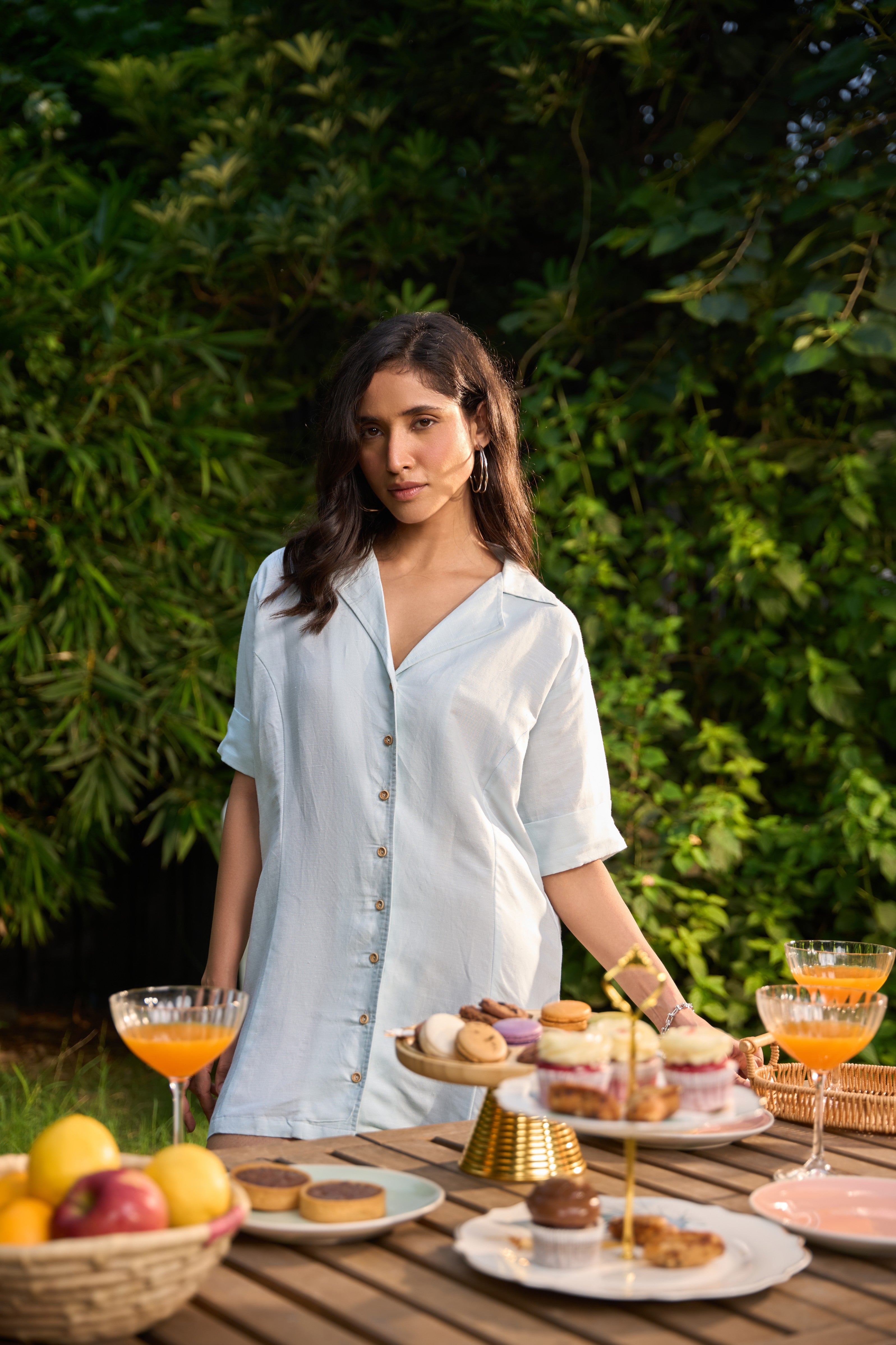 Woman standing behind a table with food and drinks outdoors