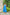Woman in a blue dress standing outdoors near a stone wall and greenery