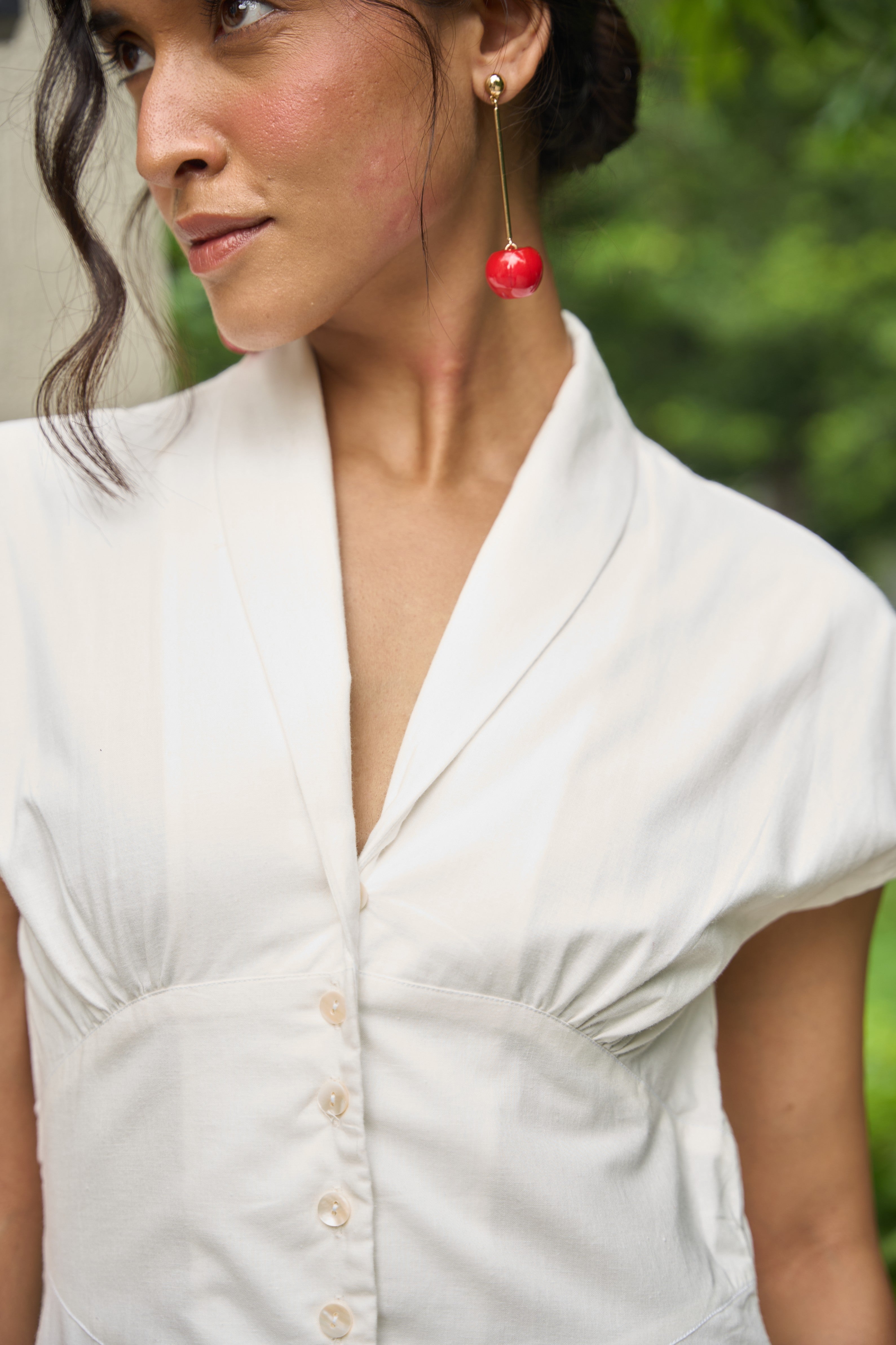 Woman wearing a white blouse with a blurred green background